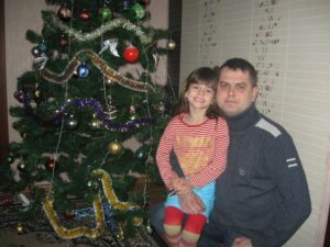 Олександр разом зі своєю донькою біля новорічної ялинки