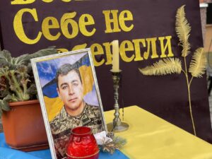 На столі портрет, свічка