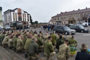 Фото. Дубнівчани  на колінах зустрічають полеглих захисникі