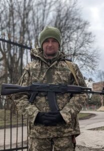 Сергій Герасимчук в повний зріст з автоматом