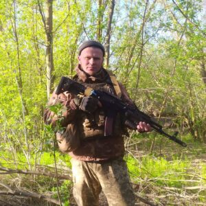 Геннадій зі зброєю на фоні  весняної природи