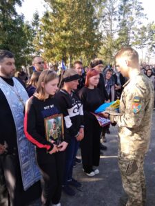 Військовий передає рідним прапор УКраїни