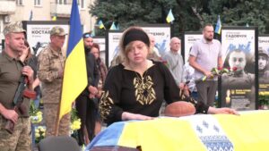 На домовині хліб і жінка в скорботі