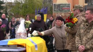 На домовині коровай, квіти. Прощання із полеглим