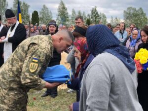 На кладовищі Військовий вручає прапор рідним