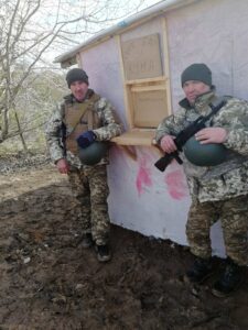 Андрій з побратимом біля будівлі