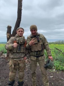 Павло разом з побратимом на фоні обрубленого дерева