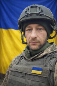 Портрет Сергія на фоні прапора