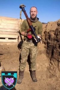 КУхоцький у повний ріст зі зброєю
