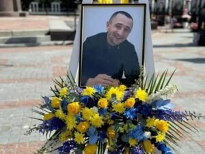Портрет Юрія. Поруч жовто-блакитні квіти